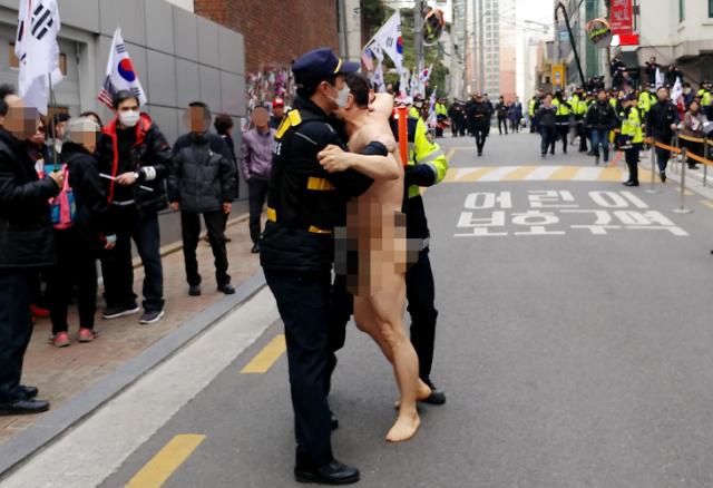 [PHOTO NEWS] Police stop naked protestor outside home of expelled president Park Geun-hye