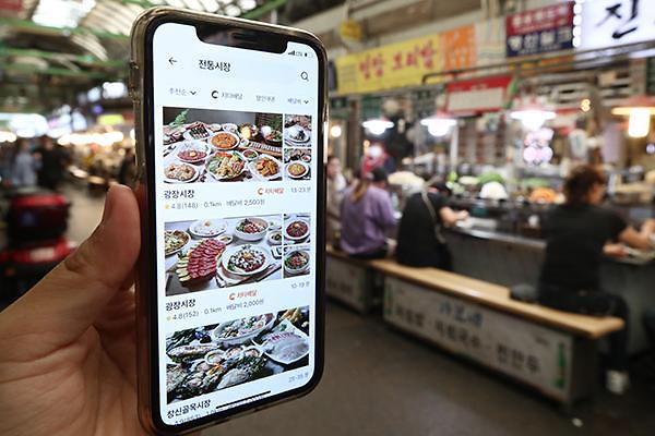 서울 광장시장에서 앱을 통해 전통시장 배달 서비스를 이용하는 모습. [사진=연합뉴스]