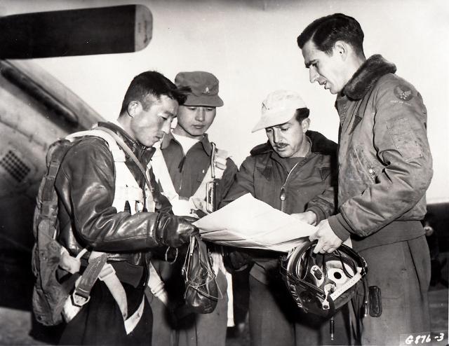 딘 헤스 대령(가장 오른쪽)을 비롯한 한미 조종사들이 전투 출격 임무에 나서기 전 작전지도를 보며 논의하는 모습.