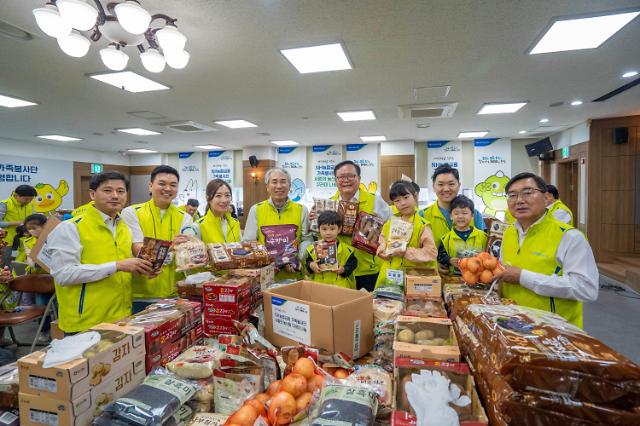 이석준 NH농협금융지주 회장(왼쪽 네 번째)을 비롯한 가족봉사단원이 15일 서울 서초구 남서울농협 본점에서 사랑의 농산물 꾸러미를 만들고 있다. 