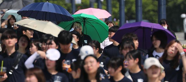 무더운 날씨를 보인 15일 오후 대구 강창교 인근 금호강 둔치에서 열린 계명대학교 'WALK 124' 걷기 행사에 참여한 학생들이 햇볕을 가리며 걷고 있다.