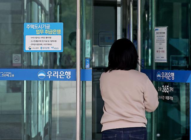은행 대출자에 부과하는 지연배상금 규모가 급증한 까닭에 국민 경제에 타격이 커졌다는 의견이 나온다. 사진은 지난달 서울 중구 우리은행 본점에서 한 시민이 영업창구로 들어서는 모습