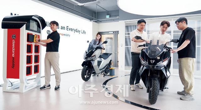 대동모빌리티가 서초구에 있는 서울사무소에 개소한 쇼룸 및 서비스센터에서 대동모빌리 직원과 고객들이 올해 4월에 출시한 배터리 교환형 전기스쿠터 GS100 및 배터리 스테이션에 대해 살펴보고 있다. 