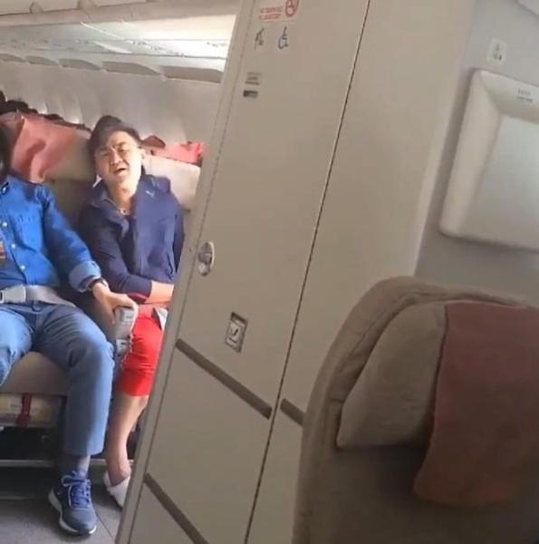문 열린 채 운항 중인 아시아나 항공기 안에 앉아 있는 이윤준씨(사진 속 빨간 바지) 모습