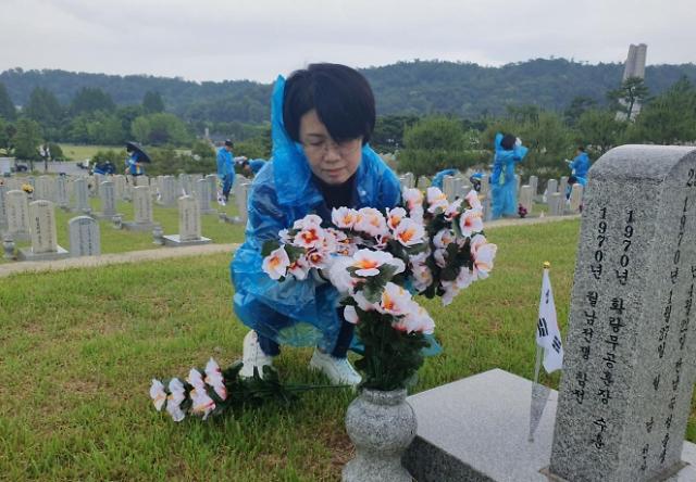 신한은행 직원이 지난 27일 서울 동작구 국립서울현충원 내 묘역에 태극기를 꽂고 헌화하고 있다. 