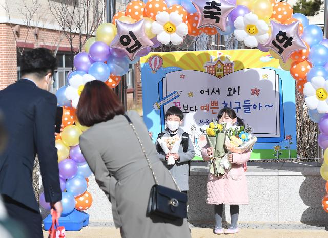 Các bậc phụ huynh đang chụp ảnh kỷ niệm với các học sinh lớp 1 tại lễ khai giảng trường tiểu học Gangbit ở Gangdong-gu, Seoul vào ngày 2/3/2023. 