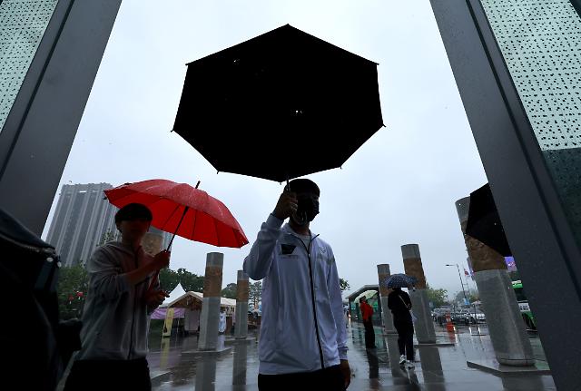 부처님 오신 날 연휴를 맞아 빗줄기가 이어지는 가운데 28일 서울 세종대로 광화문광장에서 우산을 쓴 시민들이 세종이야기 실내 관람을 위해 들어오고 있다. 