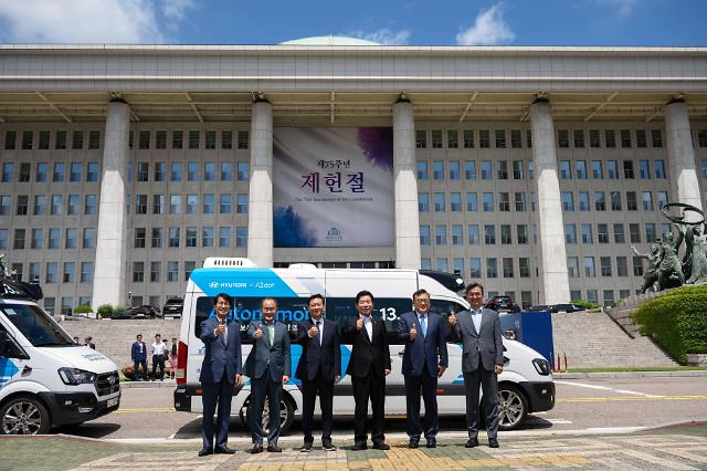 현대차와 국회사무처 관계자들이 5일 서울 여의도 국회에서 자율주행 로보셔틀과 기념사진을 촬영하고 있다 사진현대차