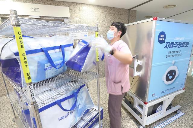 분당서울대병원 직원이 본관 3층 수술실 앞에 도착한 자동이송 로봇에서 환자 수술에 필요한 물품을 꺼내 수술실로 옮길 준비를 하고 있다 사진KT