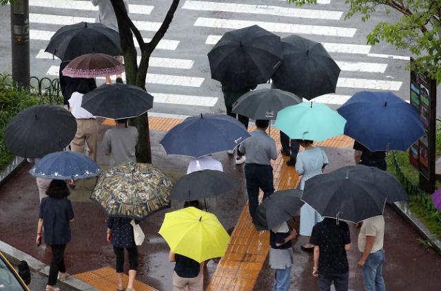 7일 광주 북구청 앞 도로에서 시민들이 내리는 장맛비에 우산을 쓰고 걷고 있다 사진연합뉴스