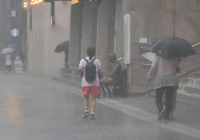 9일 오전 서울 종로구 광화문광장에 갑자기 소나기가 내리자 한 시민이 비를 맞으며 걸어가고 있다 사진연합뉴스
