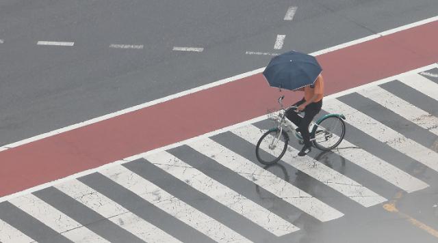 비가 내리는 8일 오후 자전거를 탄 시민이 경남 창원시 의창구 경남도청 앞 거리를 우산을 쓴 채 있다 사진연합뉴스