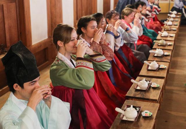 Sinh viên nước ngoài mặc hanbok trang phục truyền thống của Hàn Quốc và học nghi thức trà đạo tại Trại văn hóa và ngôn ngữ Hàn Quốc năm 2023 được tổ chức tại Làng Hanhak của Đại học Keimyung Daegu vào chiều ngày 1372023 ẢnhYonhap News
