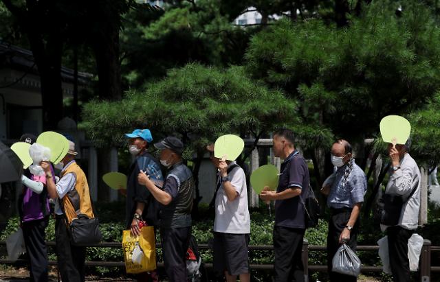 Nngười cao tuổi xếp hàng chờ nhận suất ăn miễn phí tại Công viên Tapgol ở Jongno-gu Seoul vào ngày 18 dưới cái nắng gay gắt ẢnhYonhap News