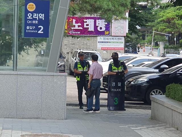 4일 오전 오리역 2번 출구에서 한 시민이 경찰과 대화를 나누고 있다. [사진=아주경제 우주성 기자]