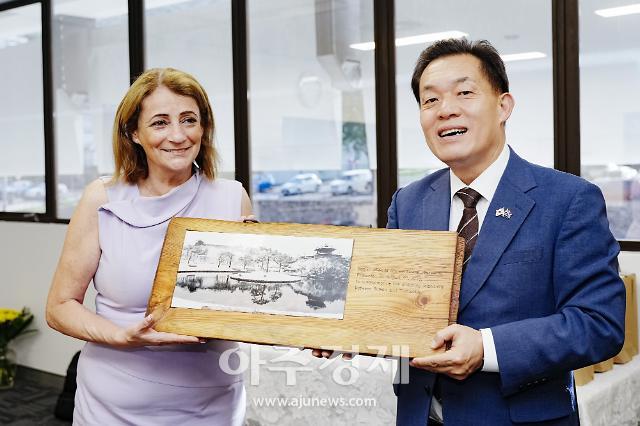 이재준 수원시장이 제니 힐 시장에게 용연과 방화수류정 설경이 담긴 나무 액자를 선물하고 있다 사진수원시