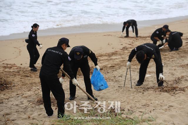 동해해양경찰서 관계자들이 17일 제6호 태풍 카눈으로 인한 하평해변 등 발생한 해양쓰레기 처리 등 환경 정화활동을 실시하고 있다사진동해해양경찰서