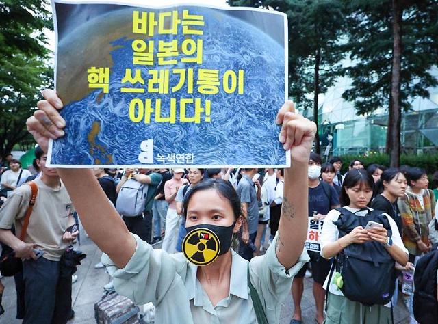  22일 오후 서울시청 앞에서 예정된 일본 원전오염수 해양투기 규탄 집회 참가자가 일본 오염수 방류 규탄 피켓을 들고 있다 사진연합뉴스DB