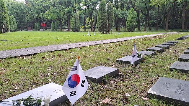 상하이 쑹칭링능원의 외국인 묘역에 한국인으로 확인 혹은 추정되는 묘지석 묘지석마다 탐방단이 준비한 태극기와 국화꽃이 놓여져 있다  사진배인선 기자