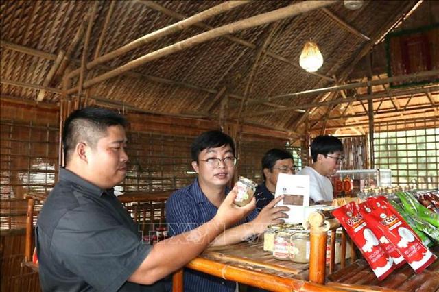 베트남 짜빈성에서 OCOP 상품에 대한 설명을 듣고 있는 관광객들 사진베트남통신사