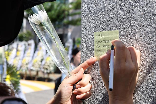 2일 오전 한 시민이 서울 양천구 소재 초등학교 앞에 마련된 교사 A씨의 추모 공간에 메시지를 남기고 있다 사진연합뉴스