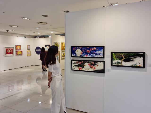 Khách hàng đang xem các tác phẩm nghệ thuật tại phòng triển lãm đặc biệt trên tầng hai của chi nhánh Lotte Mart Songpa ở Seoul vào ngày 3182023 ẢnhLotte Mart