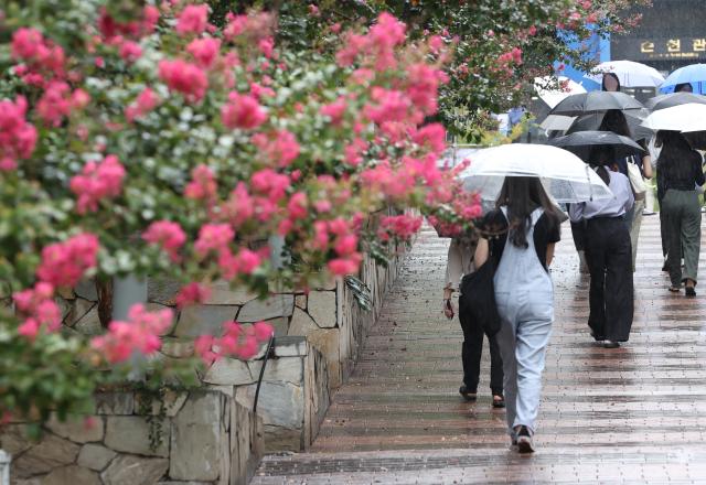 전국 대부분 지역에 비가 예보된 13일 오후 서울 용산구 숙명여대 인근에서 시민들이 우산을 쓰고 걸어가고 있다