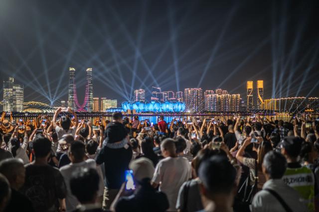 지난 19일 강변 광장에 모인 사람들이 2022 항저우 아시안 게임 개회식이 열리는 항저우 올림픽센터 스타디움을 촬영하고 있다 사진신화통신·연합뉴스