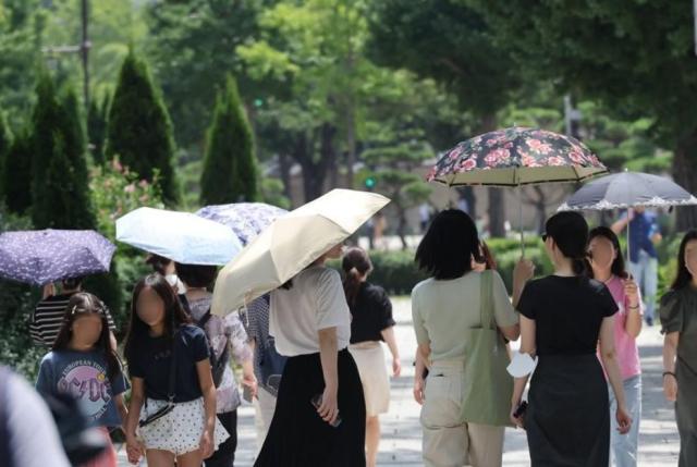 무더위가 계속된 지난 3일 서울 종로구 삼청동길에서 시민들이 강한 햇살에 양산을 쓰고 이동하고 있다사진연합뉴스