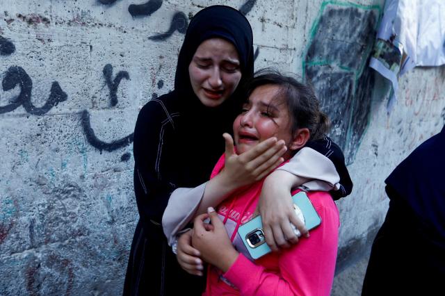 10일현지시간 팔레스타인 가자지구 남부 칸 유니스에서 무장 정파 하마스에 소속된 간부의 장례식이 열린 가운데 그의 딸이 한 여성에게 위로받고 있다 사진로이터 연합뉴스