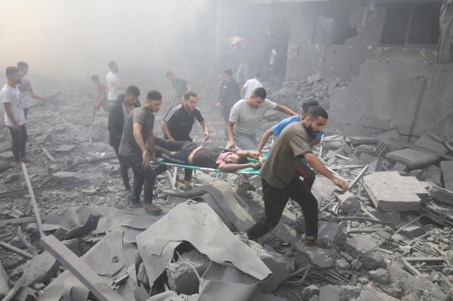 팔레스타인인들이 12일현지시간 이스라엘의 공습으로 폐허가 된 가자지구 남부 라파 난민촌에서 부상자를 대피시키고 있다 사진AP 연합뉴스