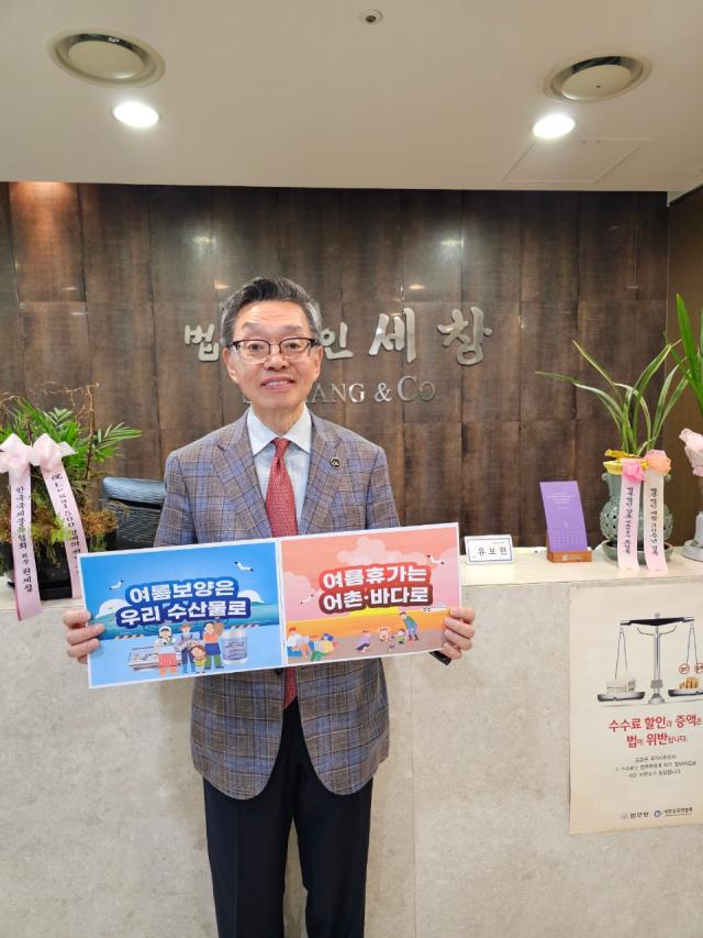 김현 법무법인 세창 대표변호사가 26일 수산물 소비 및 어촌 휴가 장려 캠페인에 참여해 사진 촬영하고 있다 사진법무법인 세창