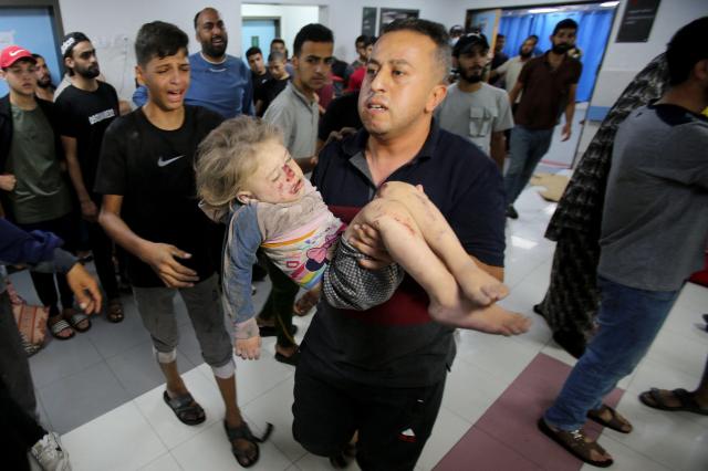 11월 4일현지시간 이스라엘군의 가자시티 내 거주지 폭격 이후 한 남성이 아이를 안고 알시파 병원으로 달려가고 있다 사진AFP 연합뉴 
