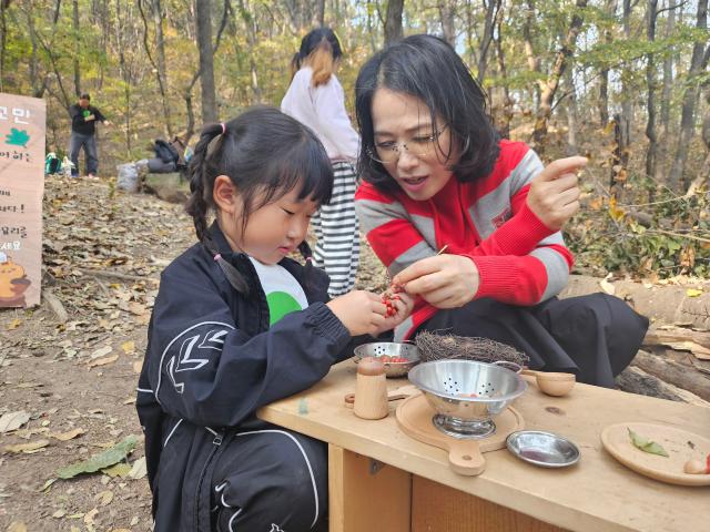 행사에 참가한 서명환씨가 어린이들에게 직접 먹거리를 연탄불에 구워주는 등 어린이들과 함께 있다사진김규남 기자