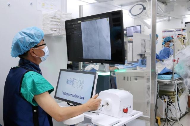 서울아산병원 의료진이 관상동맥중재술 보조로봇 에이비아AVIAR로 협심증 환자의 심장 스텐트 시술을 하고 있다사진서울아산병원