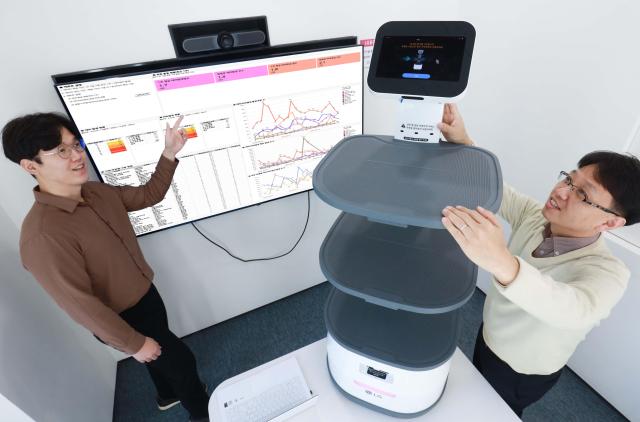LG유플러스 직원들이 로봇 이용 고객 경험을 개선하기 위해 데이터 분석 보고서를 검토하는 모습사진LGU+