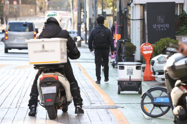 20일 오후 서울 강남구 테헤란로 일대에서 자율주행 배달로봇 뉴비와 배달기사가 도로를 오가고 있다 사진연합뉴스