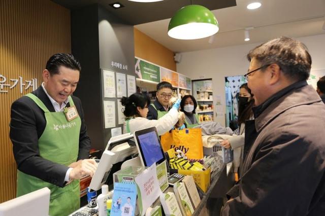 김인규 하이트진로 대표이사가 아름다운 하루 특별전에서 판매 봉사를 하고 있다 사진하이트진로