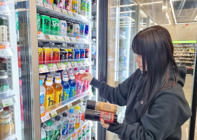 한 고객이 CU 매장에서 LF와 협업해 선보인 신제품 헤지스 음료를 살펴보고 있다  사진CU