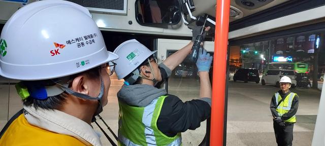 SKT 구성원들이 버스 와이파이 중계기를 구축하는 현장 모습 사진SKT