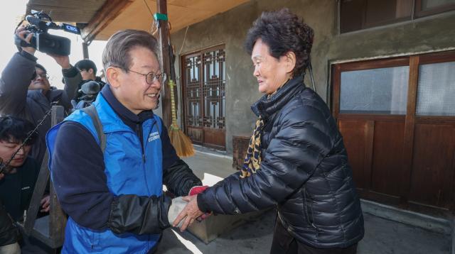 더불어민주당 이재명 대표가 4일 오전 서울 성북구 보국문로 주택가에서 연탄 나눔 봉사활동 도중 거주민과 인사를 나누고 있다 사진연합뉴스