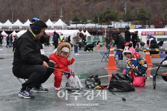 화천산천어축제장을 찾은 한 가족이 모여서 얼음낚시를 즐기고 있다사진박종석 기자