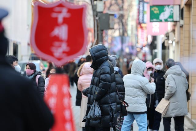 22일 서울 중구 명동에서 외국인 관광객들이 방한용품으로 꽁꽁 싸맨 채 거리를 지나가고 있다 사진연합뉴스