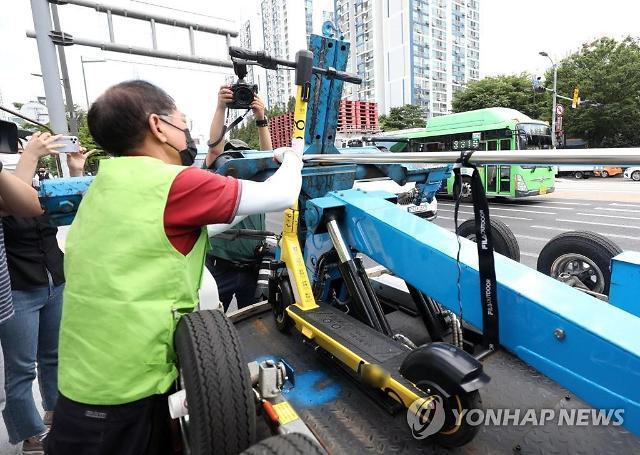 지난 2021년 7월 15일 오전 서울 송파구 가락시장역 인근에서 송파구청 관계자가 불법 주정차된 전동 킥보드를 견인하고 있다 사진연합뉴스