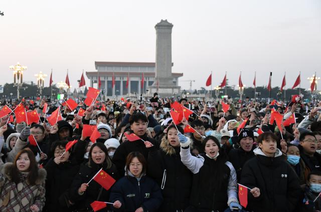 새해 첫날인 1일 중국 베이징 톈안먼 광장 국기 게양식을 보기 위해 몰려온 사람들이 중국 국기인 오성홍기를 흔들고 있다 사진신화통신