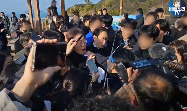 이재명 더불어민주당 대표가 2일 부산 가덕도 신공항 부지를 둘러본 뒤 기자들과 문답을 진행하며 이동 중 한 남성으로부터 습격당하고 있다 사진연합뉴스