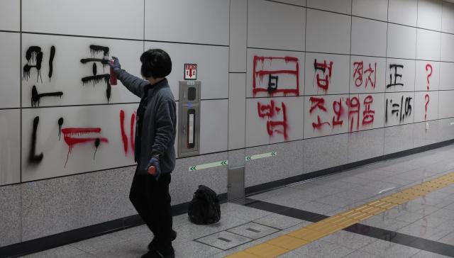 2일 서울 지하철 9호선 국회의사당역에서 직원이 낙서를 지우고 있다 사진연합뉴스