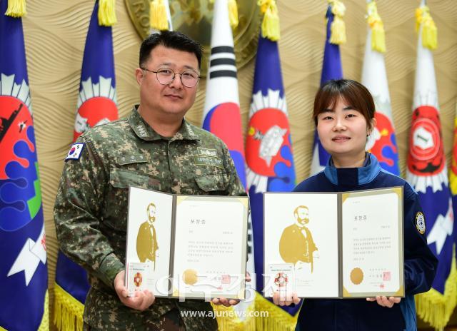 해군 1함대사령부 계획과장 장준영 대위와 1수리창 안슬기 주무관7급이 지속적인 헌혈로 대한적십자로부터 받은 포장증을 들고 기념사진을 촬영하고 있다사진해군 1함대