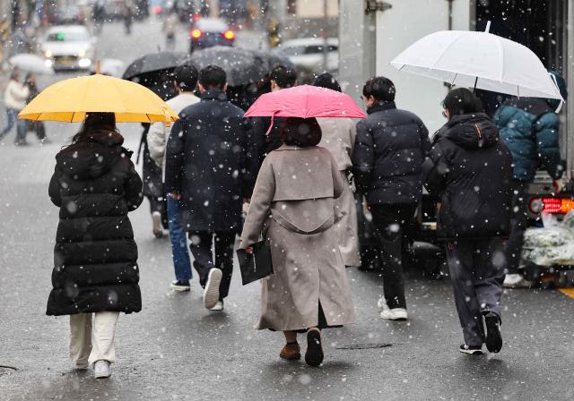 눈이 내린 17일 서울 강남구 강남역 인근에서 시민들이 우산을 쓰고 걷고 있다 사진연합뉴스