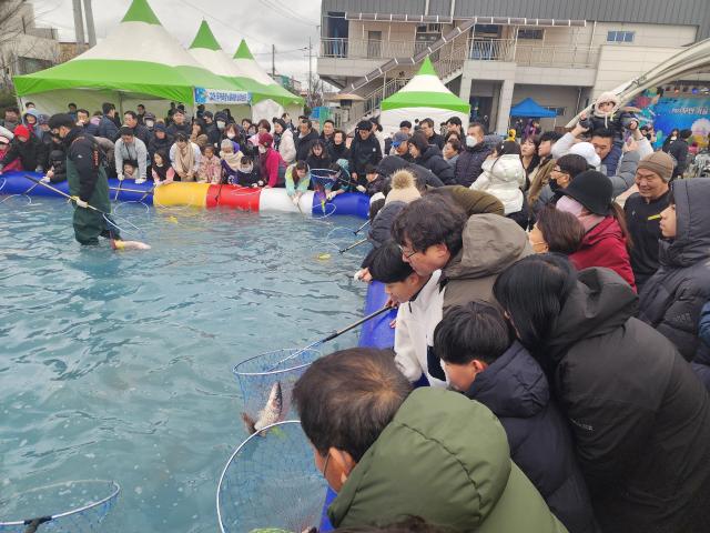 2024 무안 겨울숭어축제에 참가한 체험객이황금숭어를 잡아라 체험장에서 어린 아들과 숭어잡기 체험을 하고있다사진김옥현 기자
